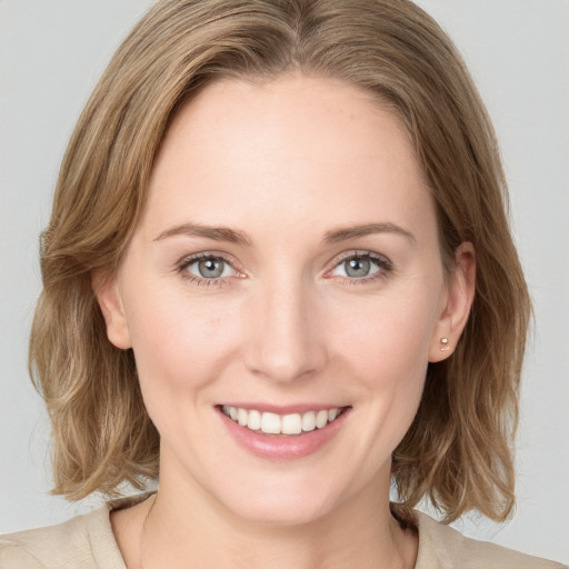 Joyful white young-adult female with medium  brown hair and blue eyes