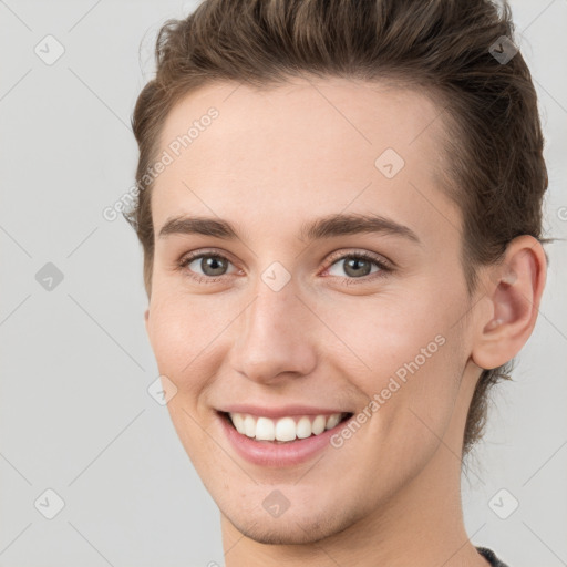 Joyful white young-adult female with short  brown hair and grey eyes