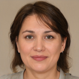 Joyful white adult female with medium  brown hair and brown eyes