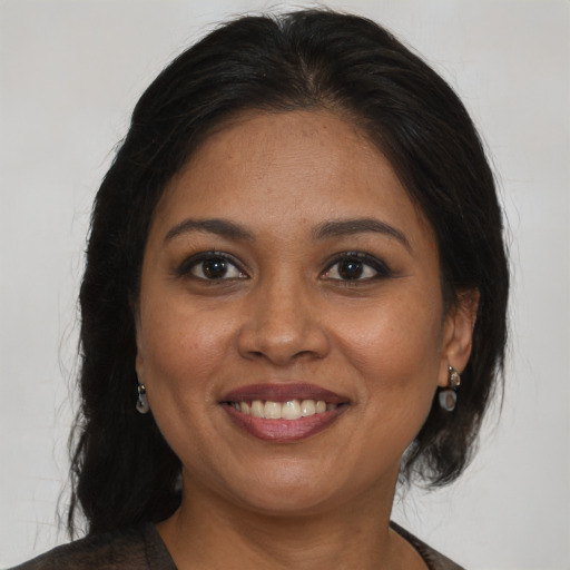 Joyful black adult female with medium  brown hair and brown eyes