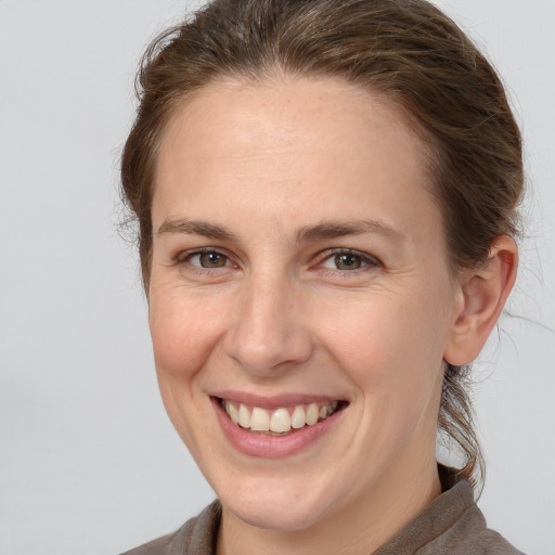 Joyful white young-adult female with long  brown hair and grey eyes