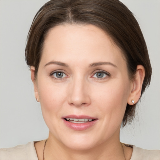 Joyful white young-adult female with medium  brown hair and grey eyes