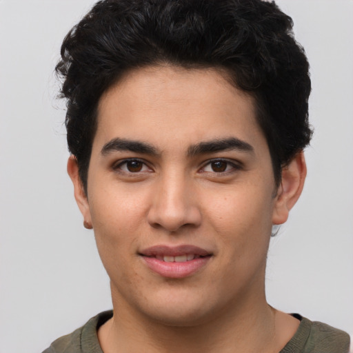 Joyful latino young-adult male with short  brown hair and brown eyes