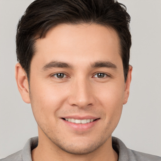 Joyful white young-adult male with short  brown hair and brown eyes