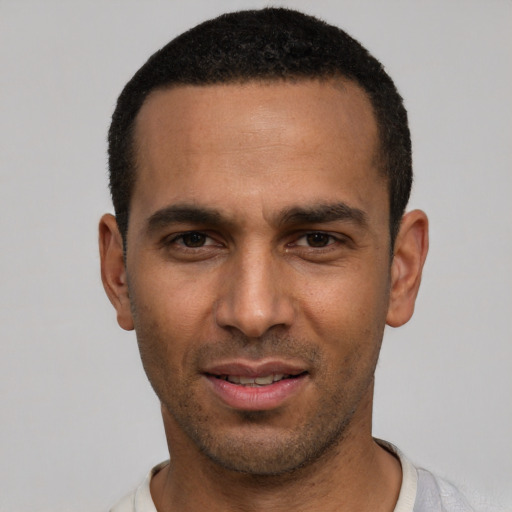 Joyful white young-adult male with short  black hair and brown eyes