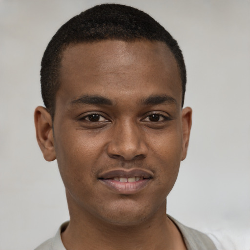 Joyful black young-adult male with short  brown hair and brown eyes