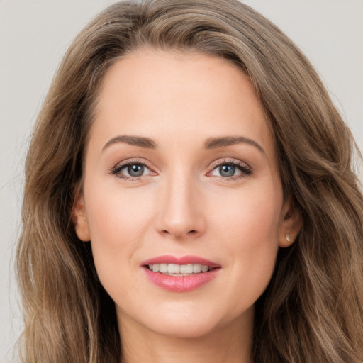 Joyful white young-adult female with long  brown hair and grey eyes