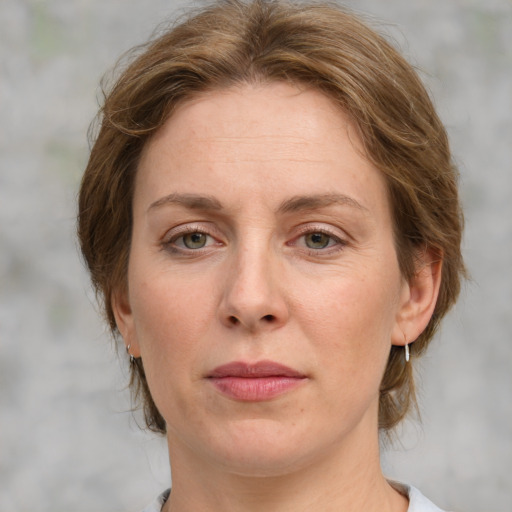 Joyful white adult female with medium  brown hair and blue eyes