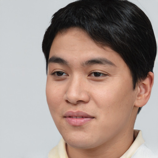Joyful asian young-adult male with short  brown hair and brown eyes