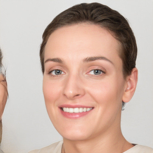 Joyful white young-adult female with short  brown hair and grey eyes