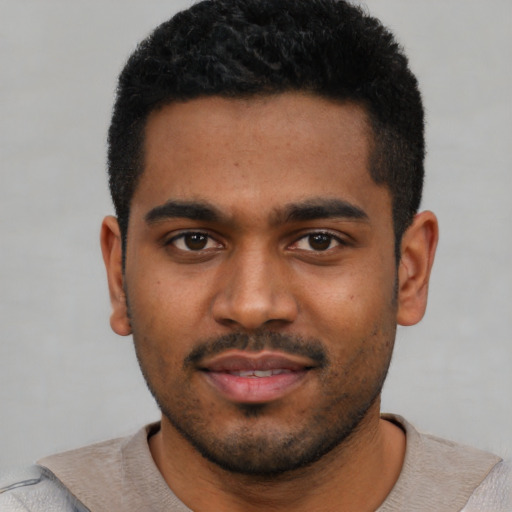 Joyful black young-adult male with short  black hair and brown eyes