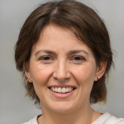 Joyful white adult female with medium  brown hair and brown eyes