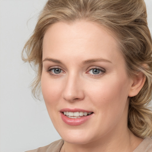 Joyful white young-adult female with medium  brown hair and blue eyes