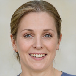 Joyful white adult female with medium  brown hair and blue eyes