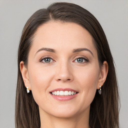 Joyful white young-adult female with long  brown hair and grey eyes