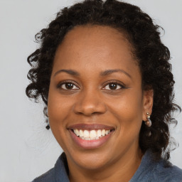 Joyful black young-adult female with medium  brown hair and brown eyes