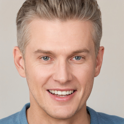 Joyful white adult male with short  brown hair and grey eyes