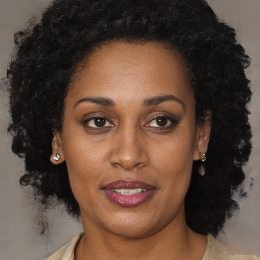 Joyful black adult female with long  brown hair and brown eyes