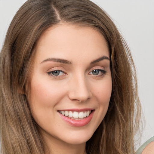 Joyful white young-adult female with long  brown hair and green eyes