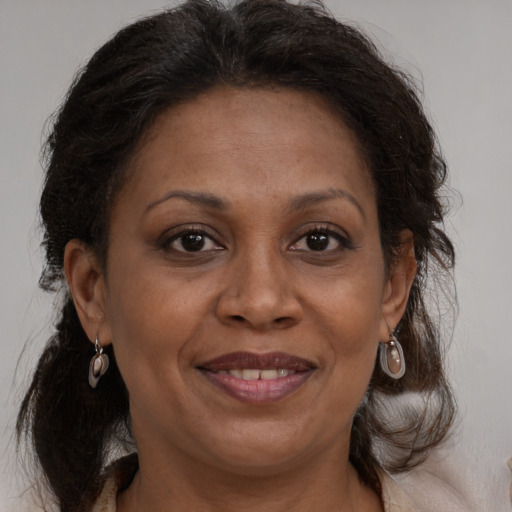 Joyful black adult female with medium  brown hair and brown eyes