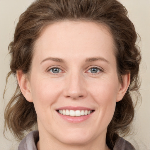 Joyful white young-adult female with medium  brown hair and blue eyes