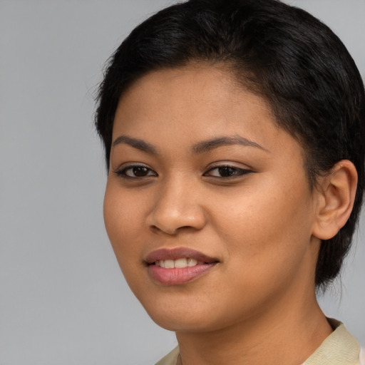 Joyful latino young-adult female with short  brown hair and brown eyes