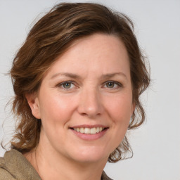 Joyful white adult female with medium  brown hair and blue eyes