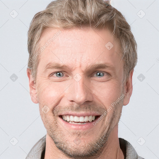 Joyful white adult male with short  brown hair and blue eyes