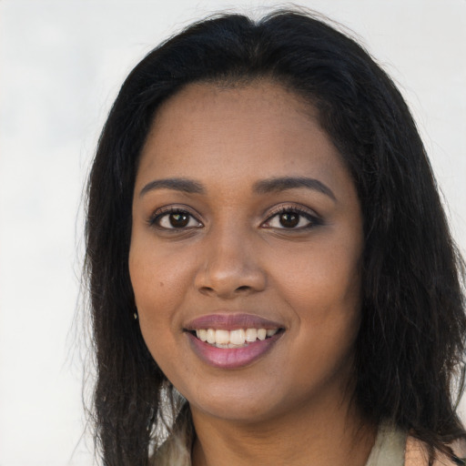 Joyful black young-adult female with long  brown hair and brown eyes