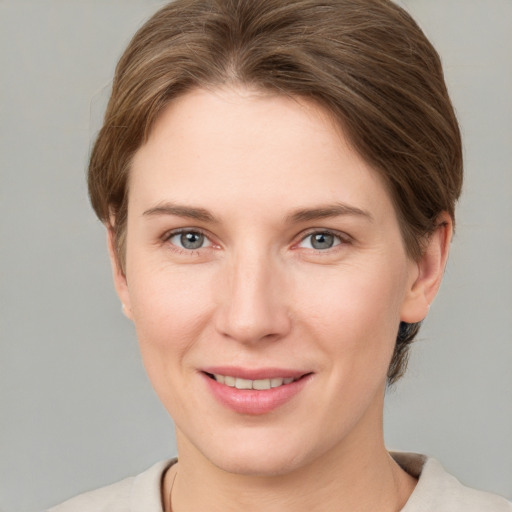 Joyful white young-adult female with short  brown hair and grey eyes