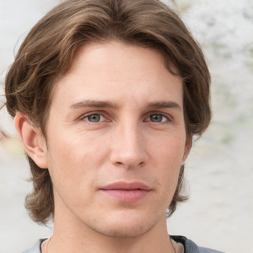 Joyful white young-adult male with medium  brown hair and grey eyes