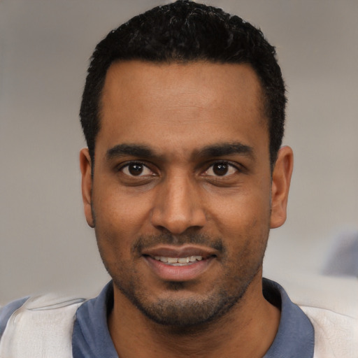Joyful black young-adult male with short  black hair and brown eyes