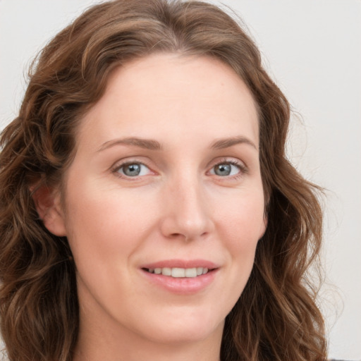 Joyful white young-adult female with long  brown hair and blue eyes