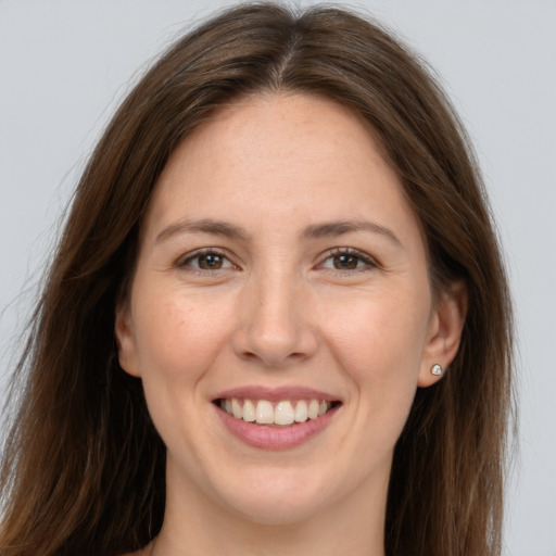 Joyful white young-adult female with long  brown hair and brown eyes