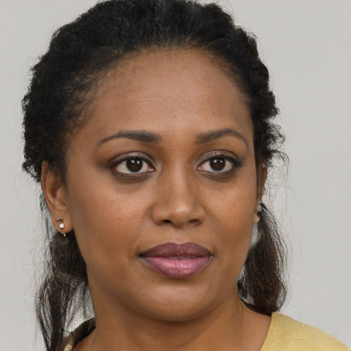 Joyful black young-adult female with short  brown hair and brown eyes