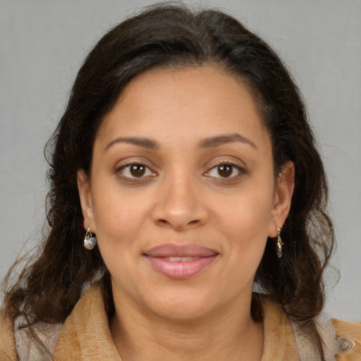 Joyful latino adult female with medium  brown hair and brown eyes