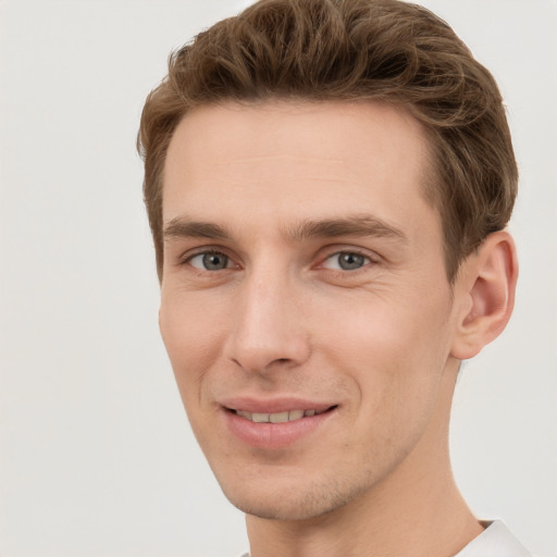 Joyful white young-adult male with short  brown hair and grey eyes