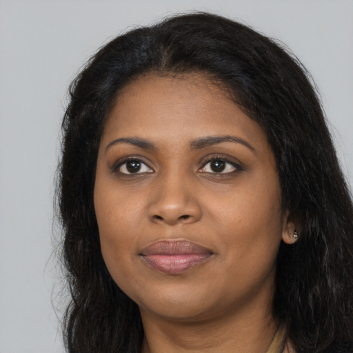 Joyful black young-adult female with long  black hair and brown eyes