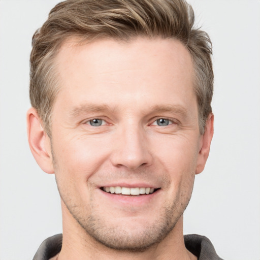 Joyful white adult male with short  brown hair and grey eyes