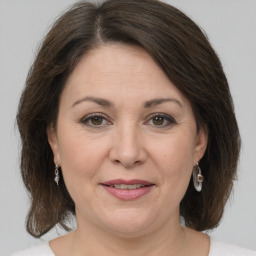 Joyful white adult female with medium  brown hair and grey eyes