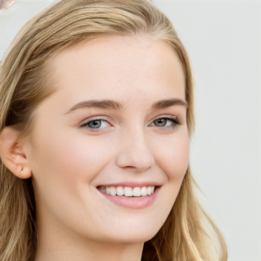 Joyful white young-adult female with long  brown hair and blue eyes