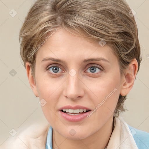 Joyful white young-adult female with medium  brown hair and blue eyes