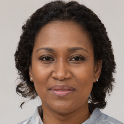 Joyful black adult female with medium  brown hair and brown eyes