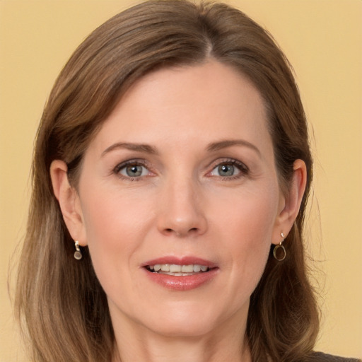 Joyful white adult female with long  brown hair and grey eyes