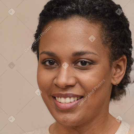 Joyful black young-adult female with short  brown hair and brown eyes