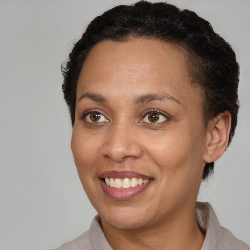 Joyful black young-adult female with short  brown hair and brown eyes