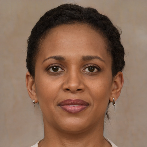 Joyful black young-adult female with short  brown hair and brown eyes
