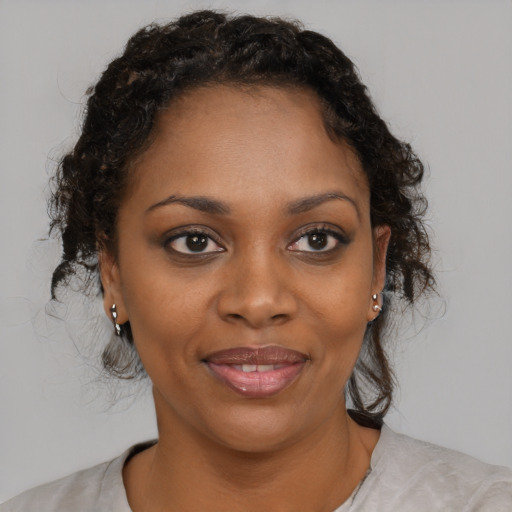 Joyful black young-adult female with medium  brown hair and brown eyes