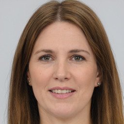 Joyful white adult female with long  brown hair and grey eyes