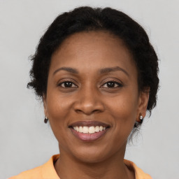 Joyful black adult female with long  brown hair and brown eyes